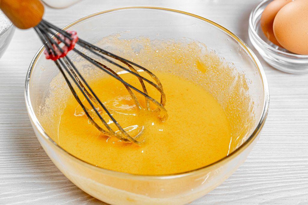 در این مرحله از تهیه کیک اسفنجی زرده و وانیل را هم بزنید تا زرده ها از حالت نیمه مایع خارج شوند.
