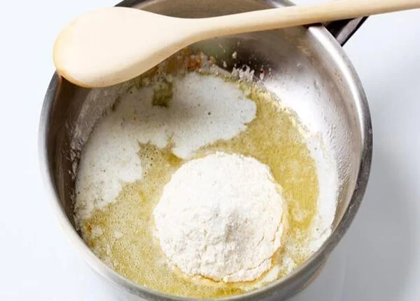 برای این مرحله از سوپ شیر، کره را در یک تابه مناسب آب می‌کنیم و آرد الک شده را به آن اضافه کنید.