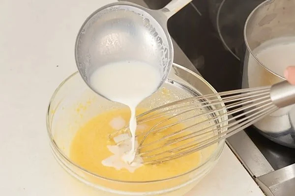 دقت کنید برای این مرحله از کیک اسفنجی از شیری استفاده کنید که به دمای محیط رسیده باشد. شیر را به آرامی به مواد اضافه کرده و هم بزنید.